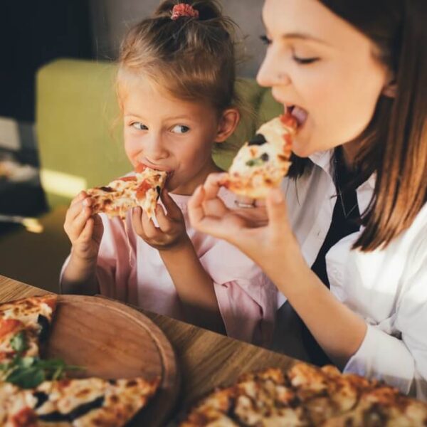 A mom and daughter eating pizza at one of the best spots in Gatlinburg.