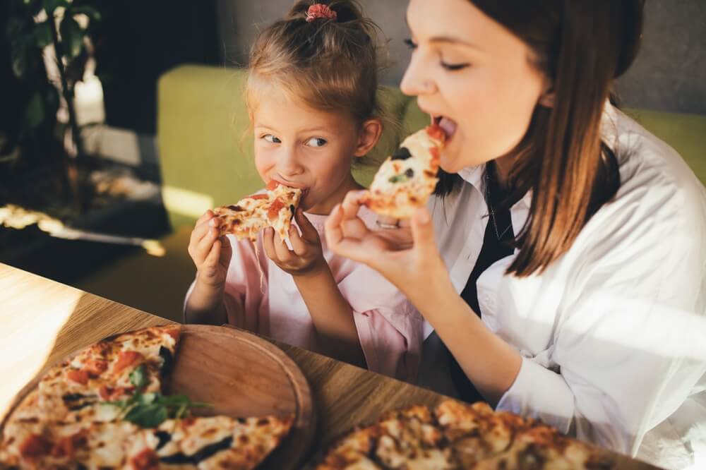 A mom and daughter eating pizza at one of the best spots in Gatlinburg.