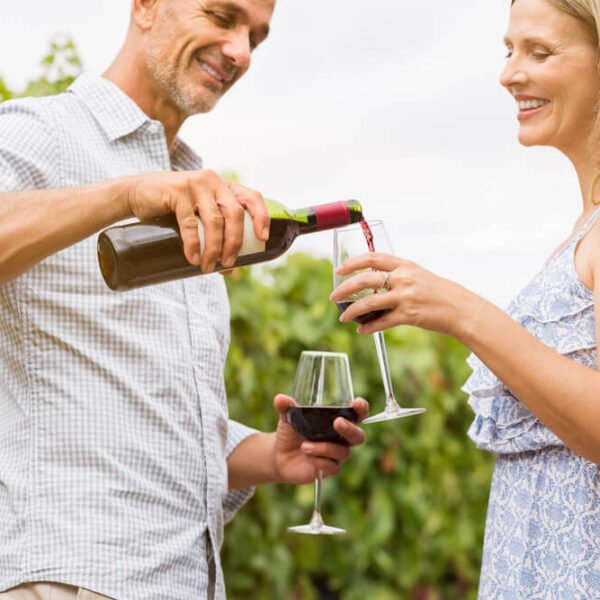 A couple pouring wine at a local winery, one of the best things to do in Gatlinburg, TN, for couples.